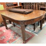 An early 20th century rectangular extending oak dining table on square tapering reeded legs, 2 spare