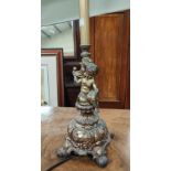 An ornate gilt metal table lamp and shade in the form of a cherub; an urn shaped table lamp and