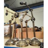 Five Victorian brass laboratory lamps with double adjustable brackets and weighted bases