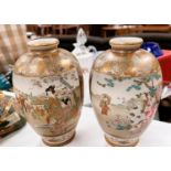 A pair of Japanese baluster vases with typical gilt decoration and genre scenes (one a.f.)