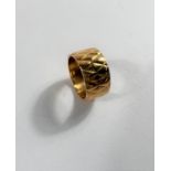 A 22 carat hallmarked gold wide wedding ring with diamond pattern, 9.33gm