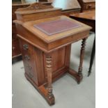 A mahogany davenport with sloped writing surface, letter rack back, drawers to one side, turned