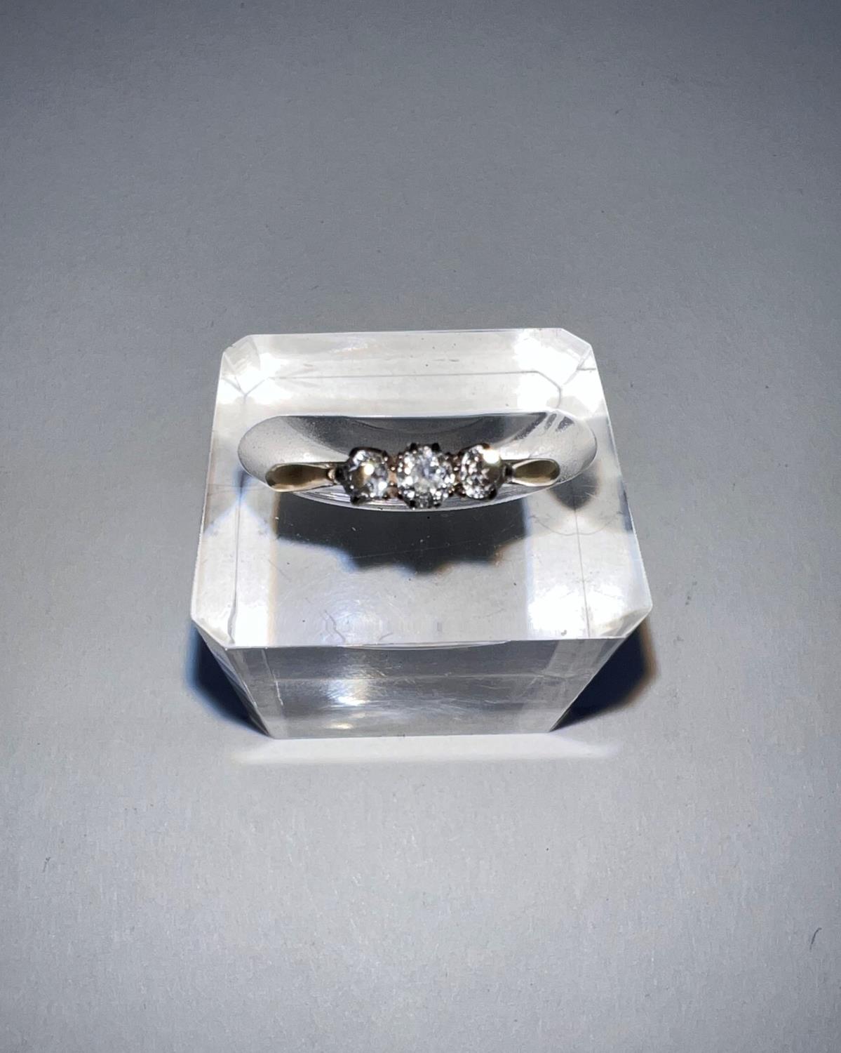 A yellow metal dress ring stamped ‘18ct’ set 3 small diamonds (central stone approximately •1