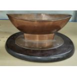 An Arts & Crafts copper table centre in the form of a boat, on a wooden stand, Length 33cm