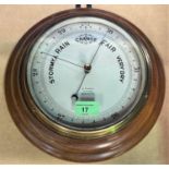 An aneroid barometer in circular stained wood frame by Franks, Manchester
