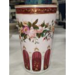 A 19th century cranberry glass vase of tapering cylindrical form, overlaid and cut back in white