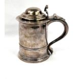 An early Georgian hallmarked silver quart tankard of ribbed cylindrical form, with domed hinged