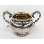 A 19th century hallmarked silver 2-handled bowl of squat circular form, with chased decoration and