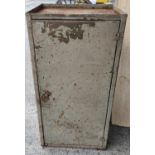 A metal industrial collectors cabinet with swing door and interior drawers, tray top
