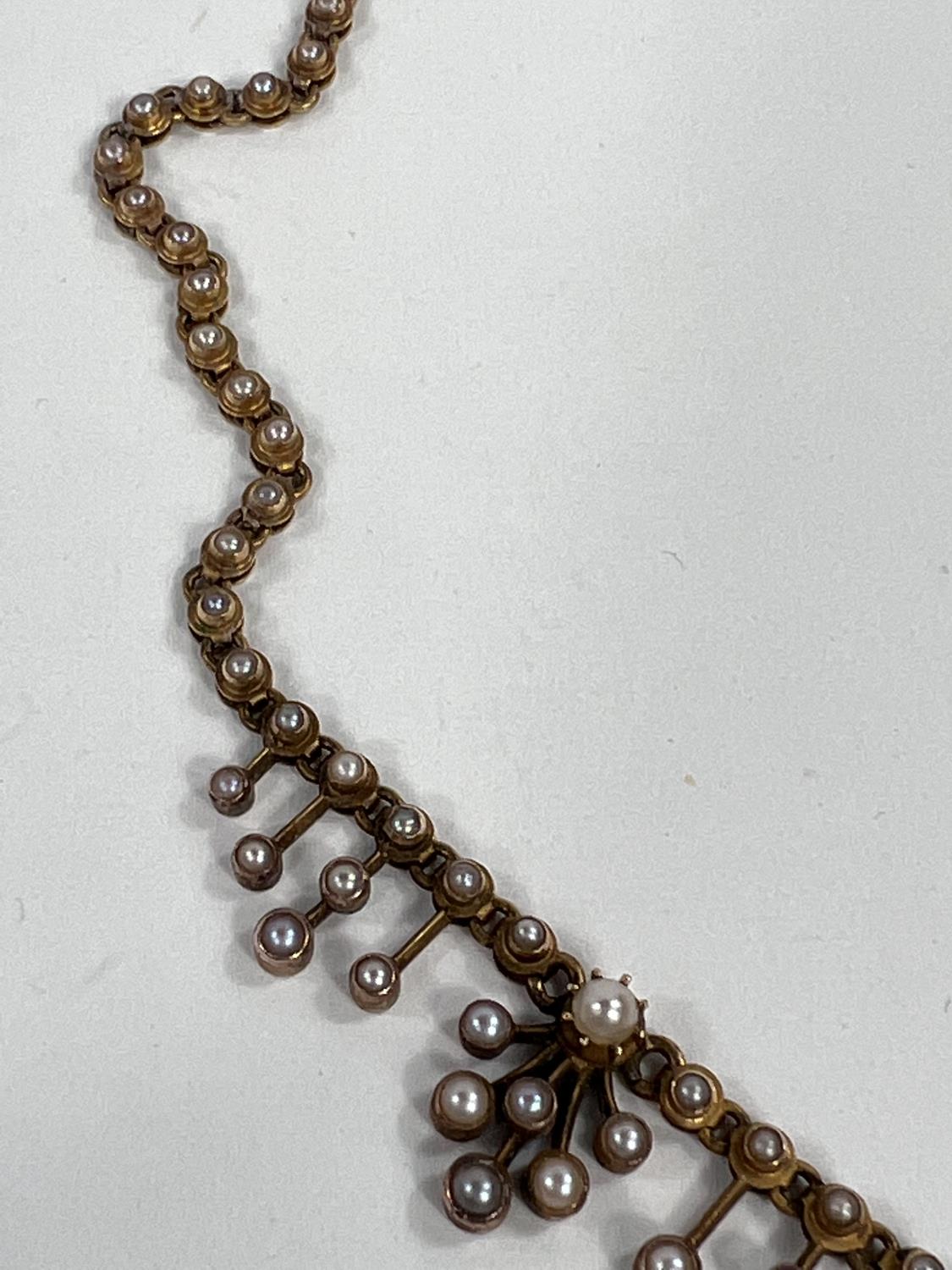 A Victorian yellow metal necklace, each link set with a seed pearl, tiered drops, the central with - Image 3 of 3