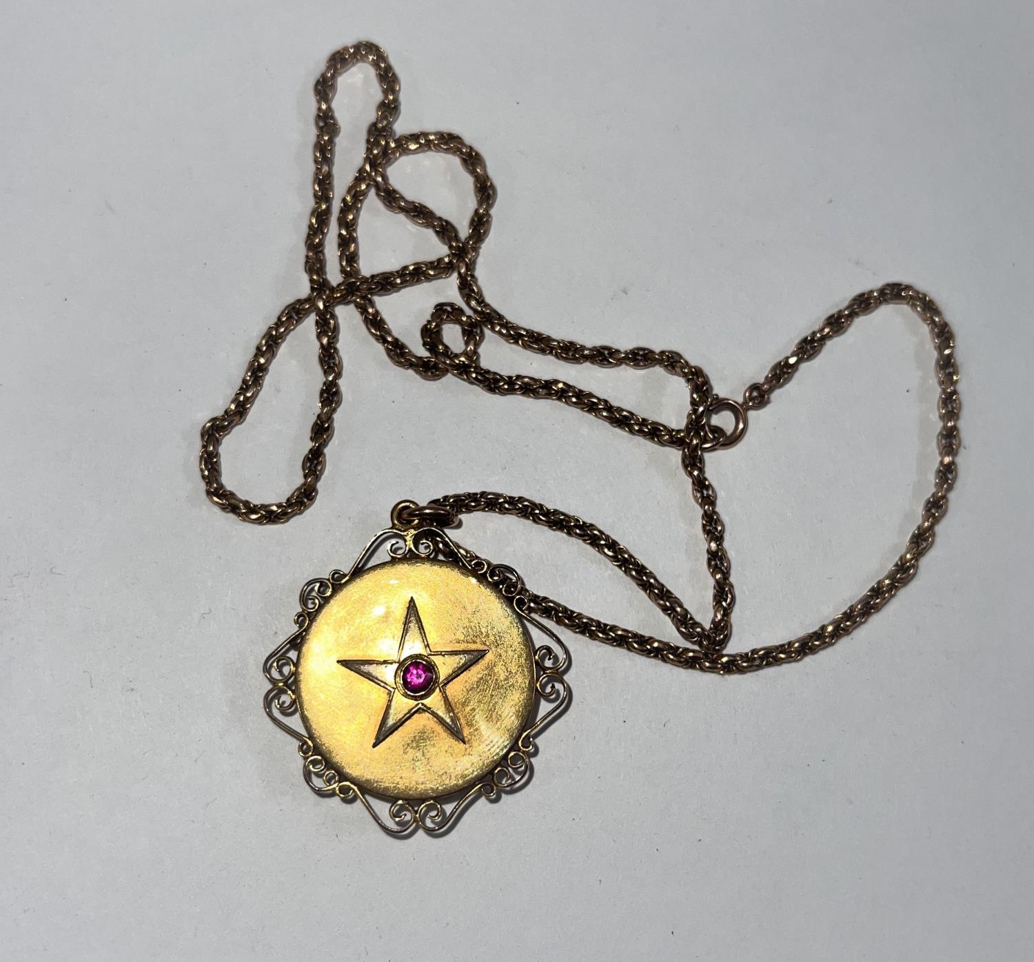 A Victorian 15 carat hallmarked gold pendant/ locket set with a ruby within a star, having scroll - Image 2 of 2