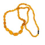 A string of graduated butterscotch beads, 1 - 3cm, 118cm length