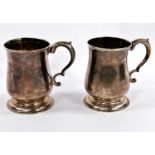 A Georgian hallmarked silver pair of baluster half pint mugs with scroll handles and raised circular