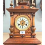 An Edwardian mantel clock with striking movement in architectural walut case (no glass door)