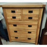 A modern light wood chest of three long, four short drawers height 119cm length 98cm depth 43cm