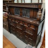 An oak carved court cupboard with bulbous support, grape carving