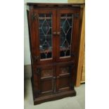 An oak old charm stereo cabinet with bevelled glazed door above and below