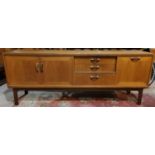 A 1960's G-Plan teak lowline sideboard with double cupboard, single cupboard and 3 drawers Length