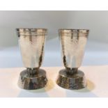 A pair of silver modernist designer cylindrical planish candlesticks with flared rims and bases, ht.