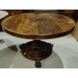 A 19th century rosewood tilt top circular dining table on octagonal tapering column, on three