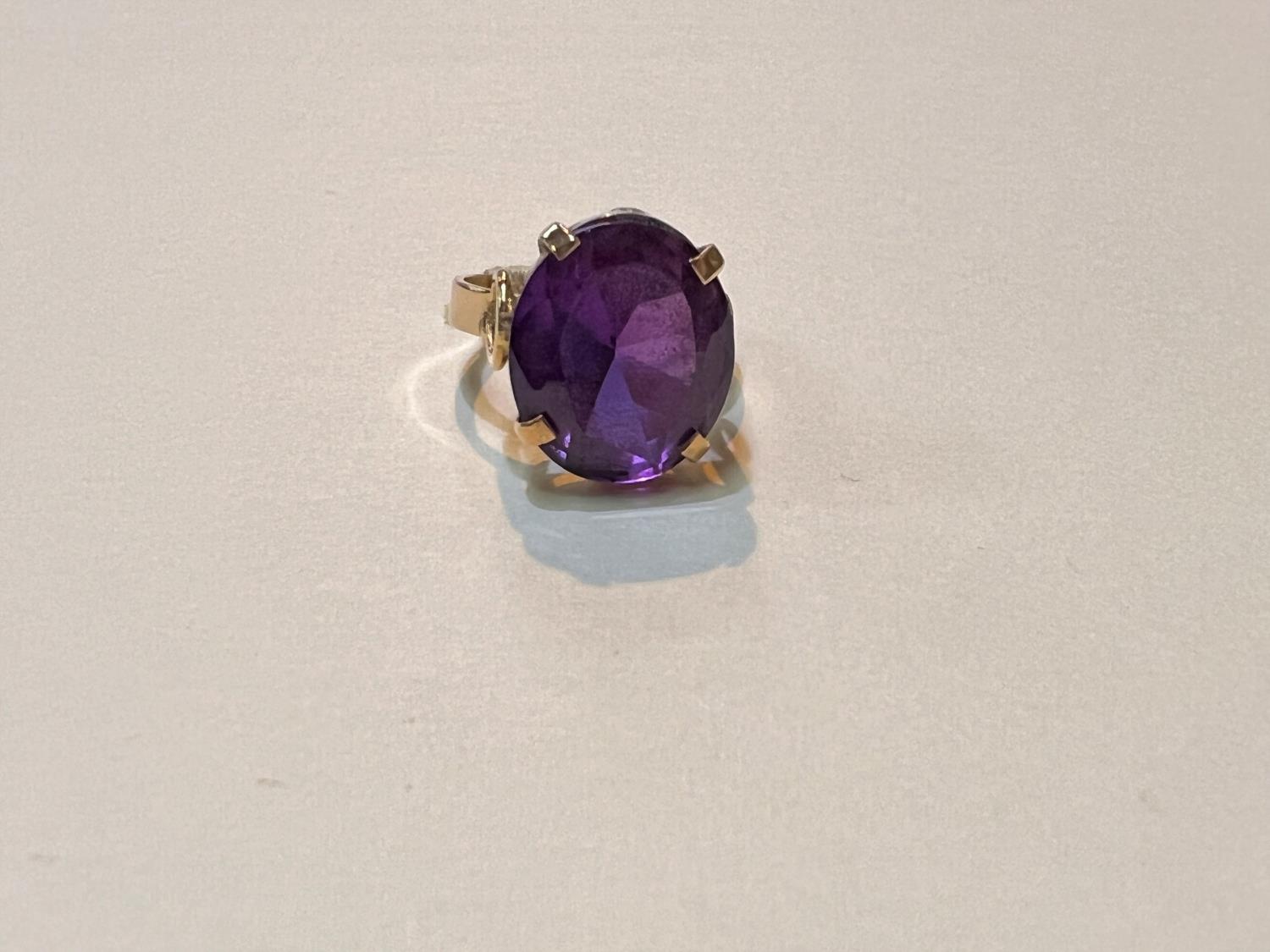A yellow metal ring with large amethyst stone, Egyptian marked, weight 5.9gms, size M.