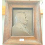 A relief bronze plaque in oak frame, side view head and shoulders of Sir Evan Spicer, 27.5 x 20cm
