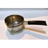 A 19th century white metal, possibly French, brandy sauce pan with ebonised squared handle, with