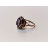 A 9ct gold ring with an oval faceted stone and a roped border, size L, weight 2.6gms.