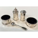 A pair of circular salts with ble glass liners; 2 pepper pots, 5oz; a silver plated salt spoon