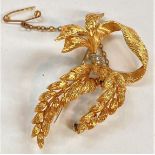 A yellow metal brooch in the form of a bow ad fern leaves, set 2 small diamonds, impressed mark