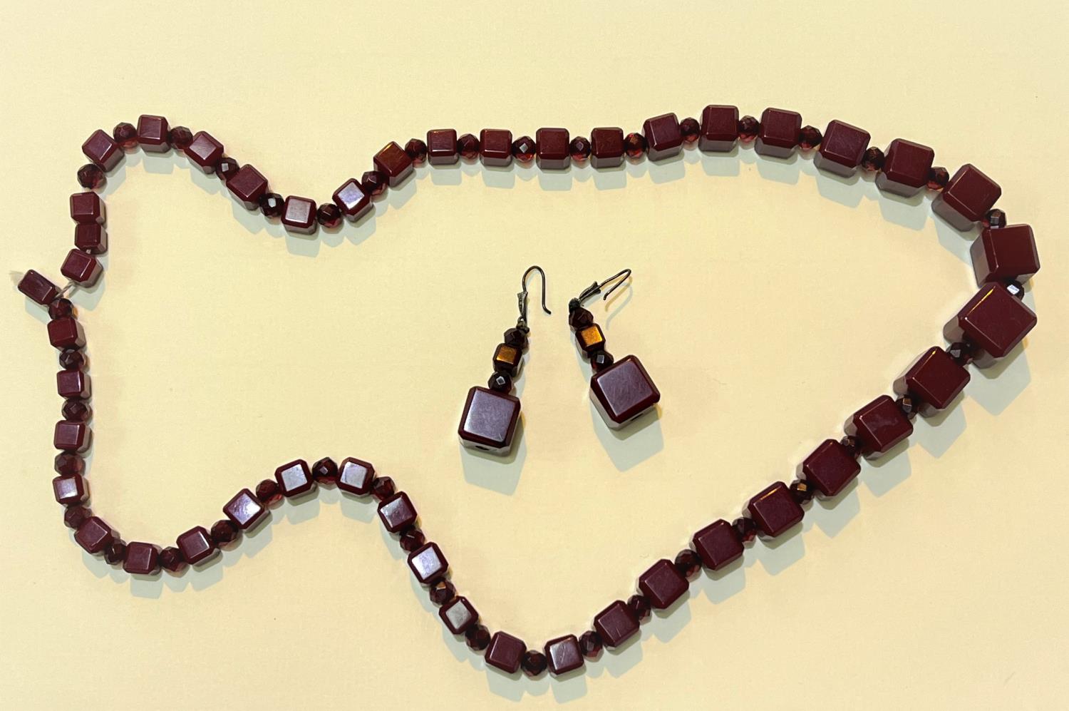 A cherry amber Bakelite necklace of graduating cube form with clear faceted beads between and a