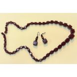 A cherry amber Bakelite necklace of graduating cube form with clear faceted beads between and a