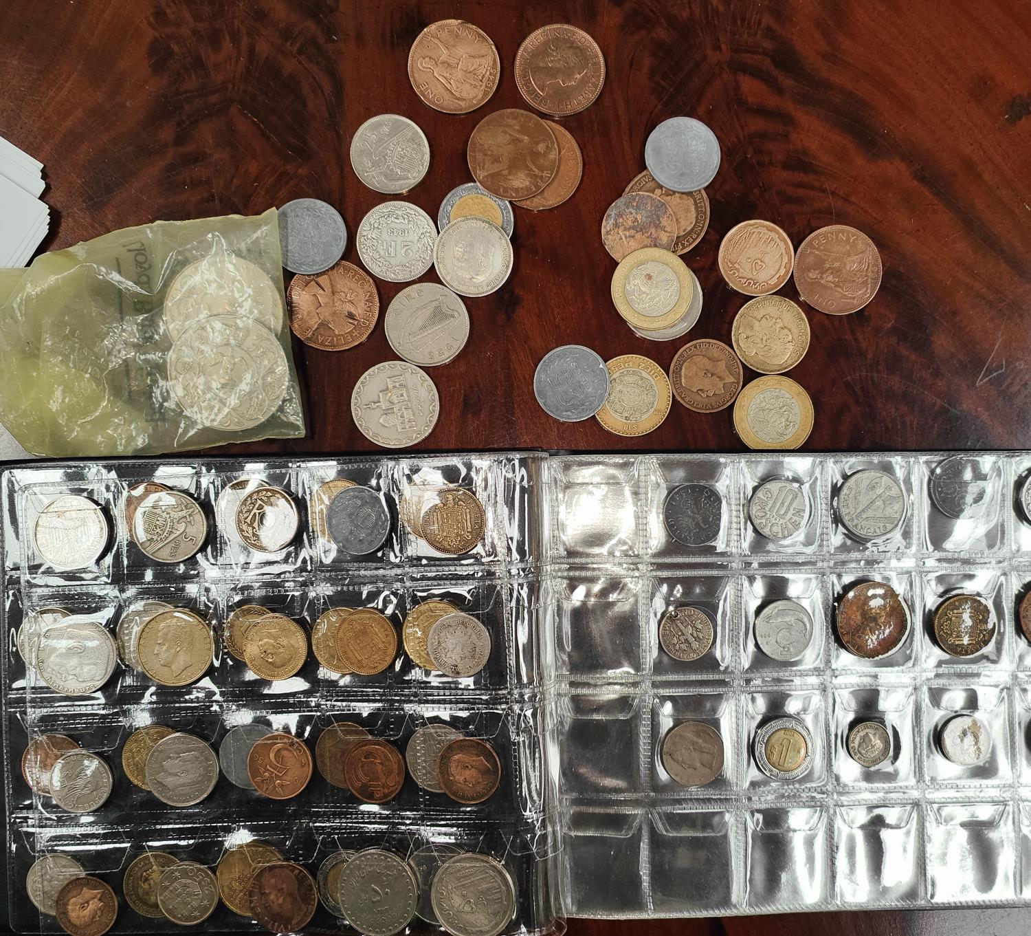 An album and loose world coins, some silver content, some WWII German examples.