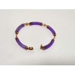 A Chinese Lilac Jade Bracelet with 14 carat gold mounts.