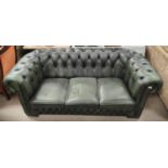 A three seater Chesterfield settee with deep button back, studded arms in antique green leather