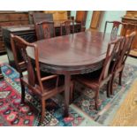 A Chinese hardwood dining suite comprising table with rounded extending top, 3 spare leaves,