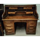 A 1930's large serpentine roll top desk, with fully fitted interior, pillar drawers to either side