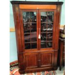 An early 19th century floor standing corner cabinet with dentil cornice, in inlaid mahogany with
