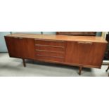 A mid 20th century long low teak sideboard by Macintosh with double cupboards to either end and 4