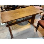 A 1950's arts and crafts oak and ash dining table with trestle supports united by stretcher, 121 x