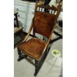 A stained wood rocking chair with decoration to back