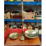 A brass and oak set of balance scales with weights