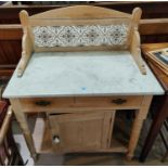 A Victorian pine marble top wash stand with cupboard below, tile back