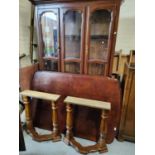 A wooden dining table and four chairs with high backs and a bookcase/side cabinet, glazed above,