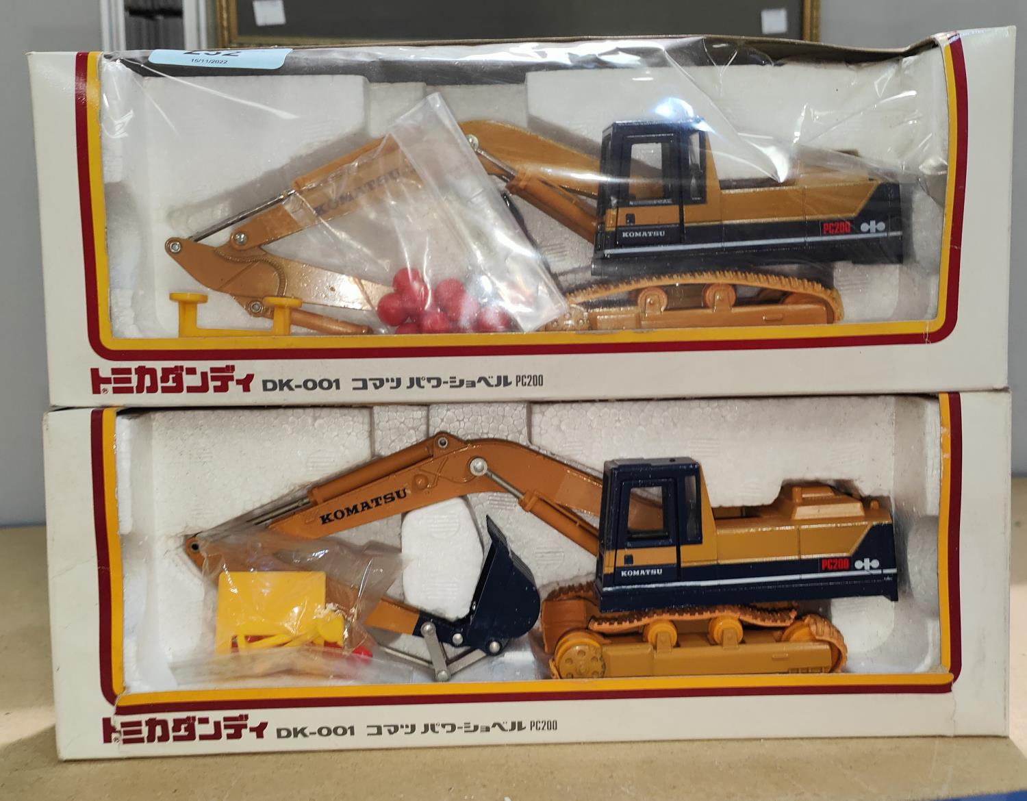 Two boxed Komatsu Tomica Dandy 1/43 scale DK-001 PC200 diecast digger (one plastic front missing)