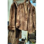 A full length brown fur coat and a similar brown fur half length jacket