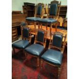 A set of 10 oak dining chairs, overstuffed, with carved finials, studded backs and seats, on