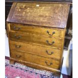 An Edwardian oak bureau with fall front over 4 drawers