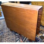 A teak mid century drop leaf kitchen table with squared edges, length 144cm