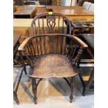 A 19th century elm Windsor armchair with low back, on turned legs with crinoline stretcher